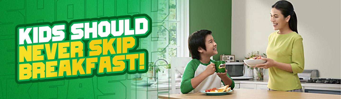 mother and kid not skipping breakfast while holding green milo mug on the family dining table horizontal image
